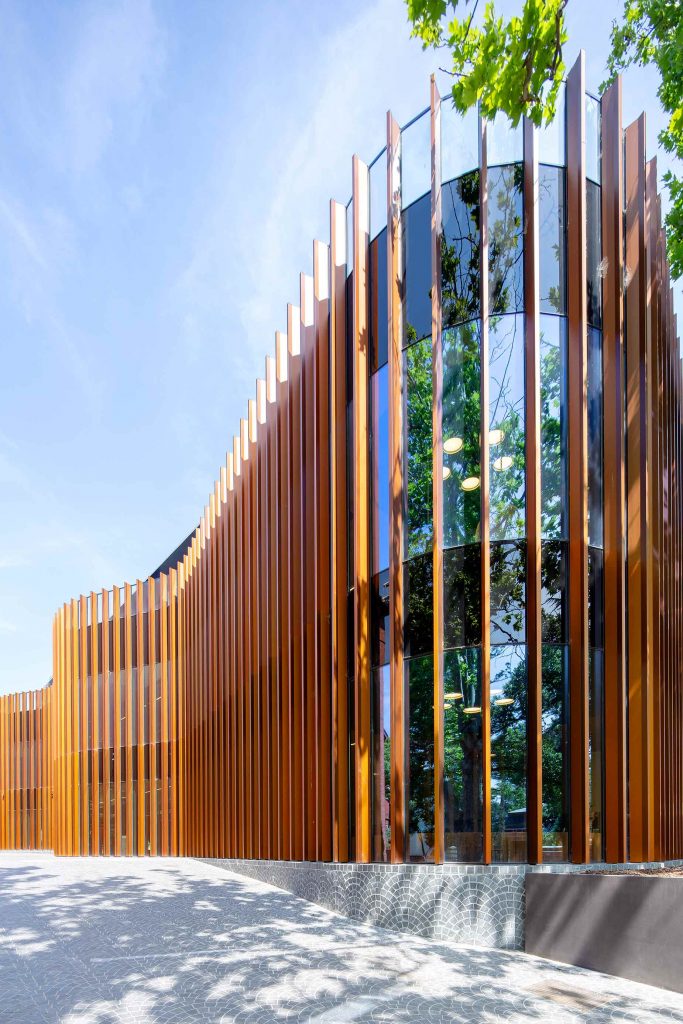 A modern school wellness centre surrounded by lush greenery.