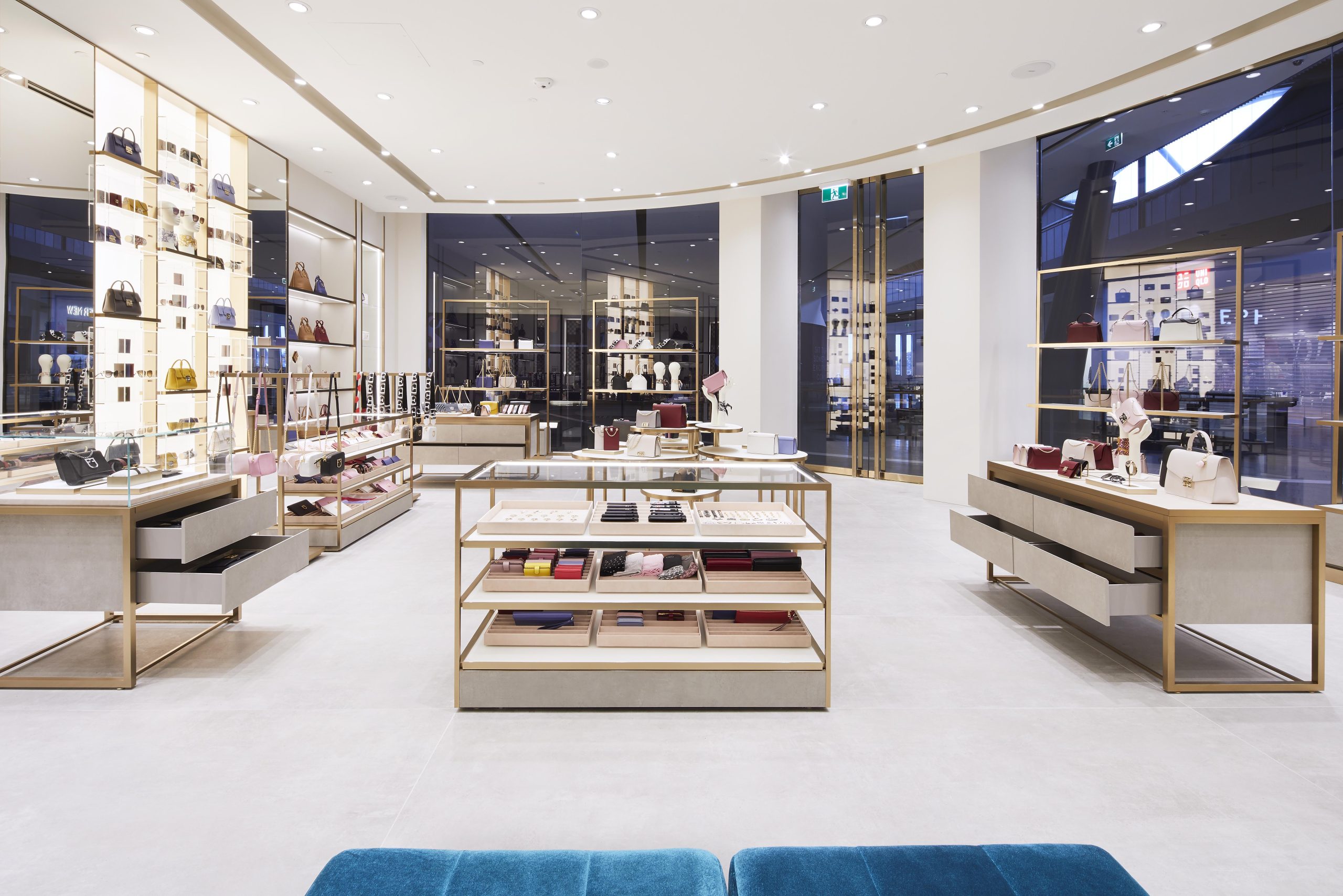 Luxury accessories boutique interior with illuminated display walls, sleek counters and handbags arranged on elegant shelving.