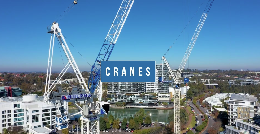 Aerial city view with multiple tower cranes above commercial buildings and “Cranes” title overlay.
