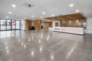 Bright commercial lobby for Toyota Material Handling with polished concrete floor, timber battens and reception desk.