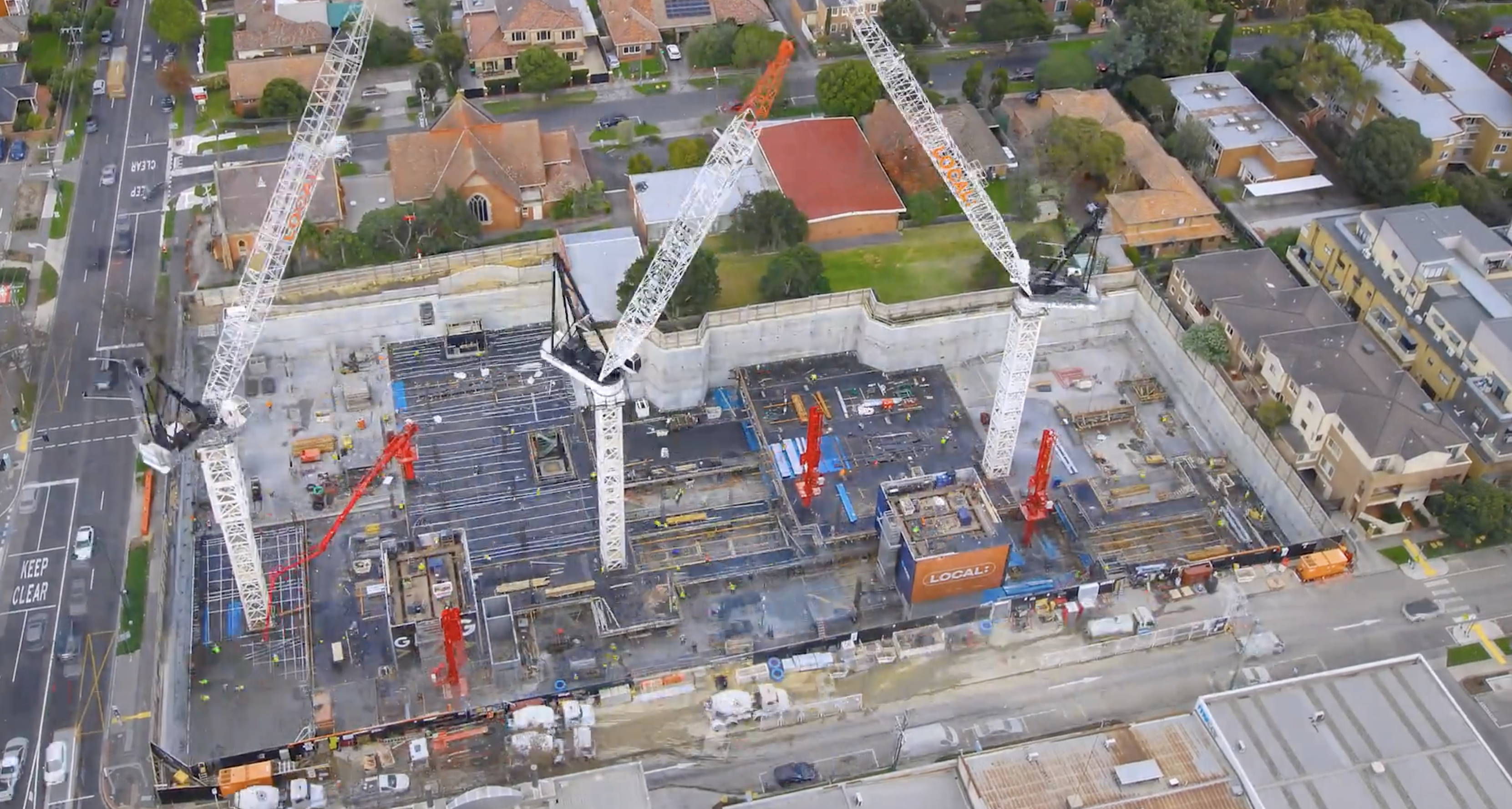 A time-lapse image capturing the construction progress of a multi-story building with cranes and workers actively involved on-site, showcasing the use of professional construction progress documentation.